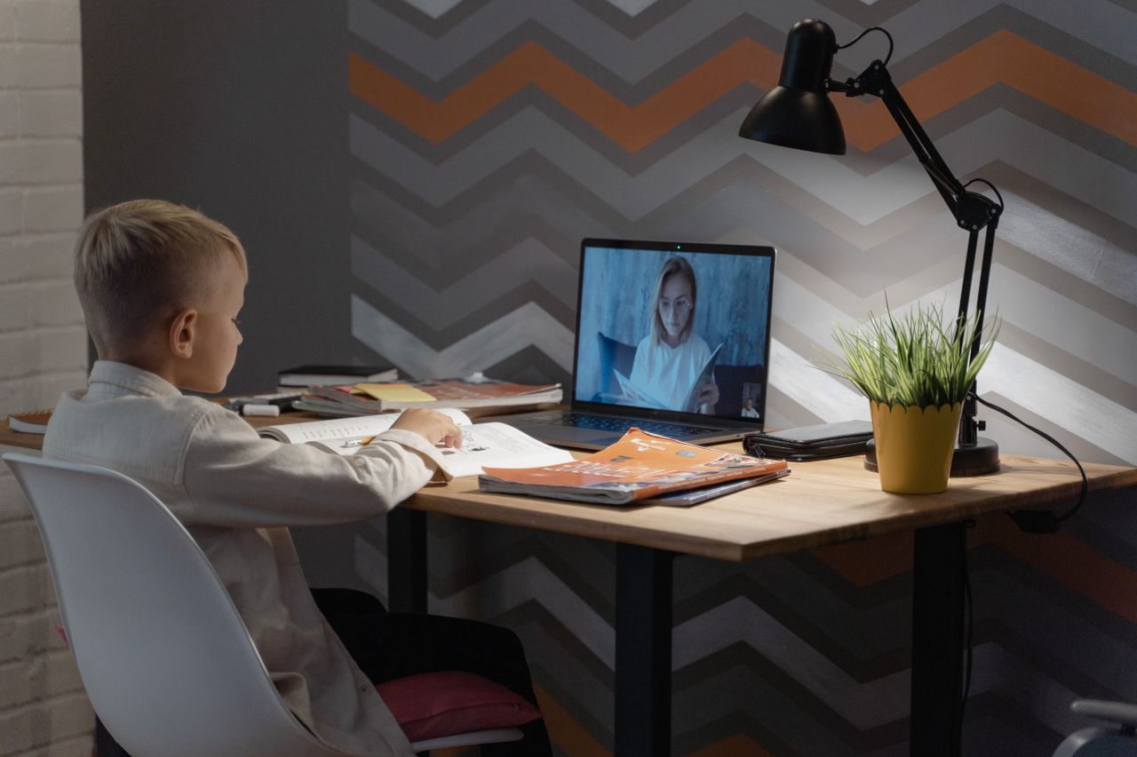 A student learning online with a teacher on a laptop